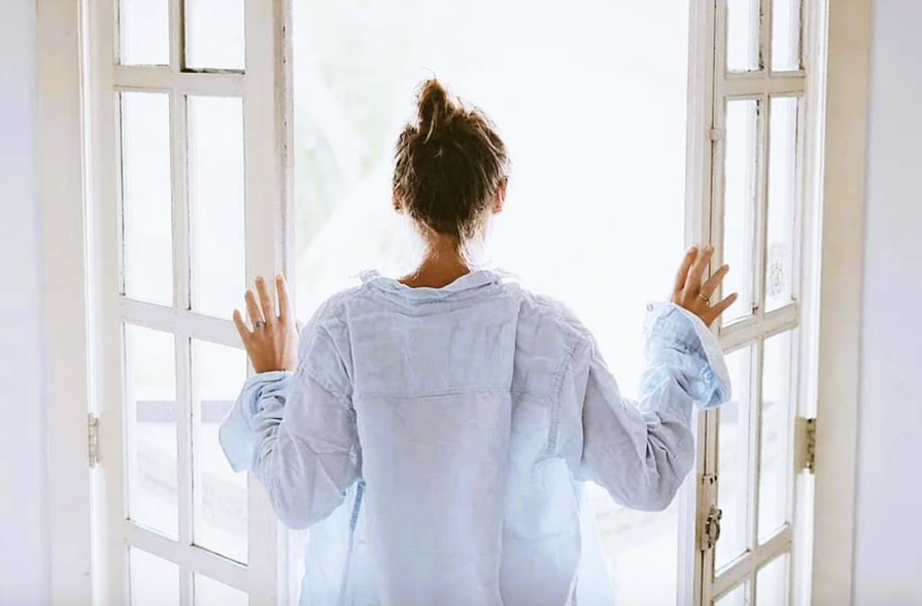 woman opening doors in morning for 
fresh air